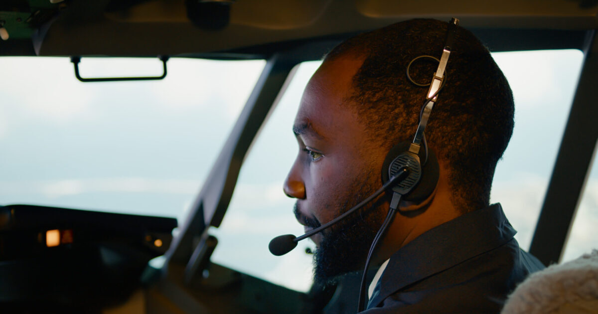 African american copilot taking off with airplane captain
